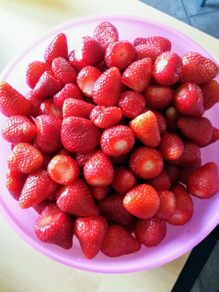 Fresh strawberries in a pink bowl